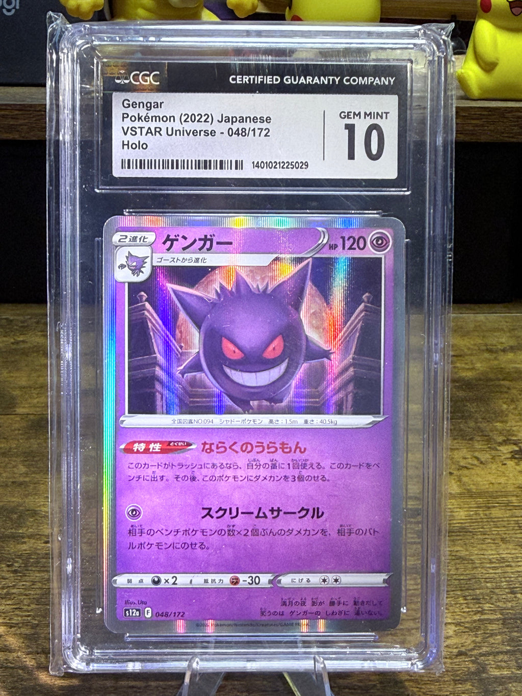 A graded holographic Pokémon trading card of Gengar from the 2022 Japanese VSTAR Universe set, encapsulated in a CGC holder and displayed on a wooden surface.